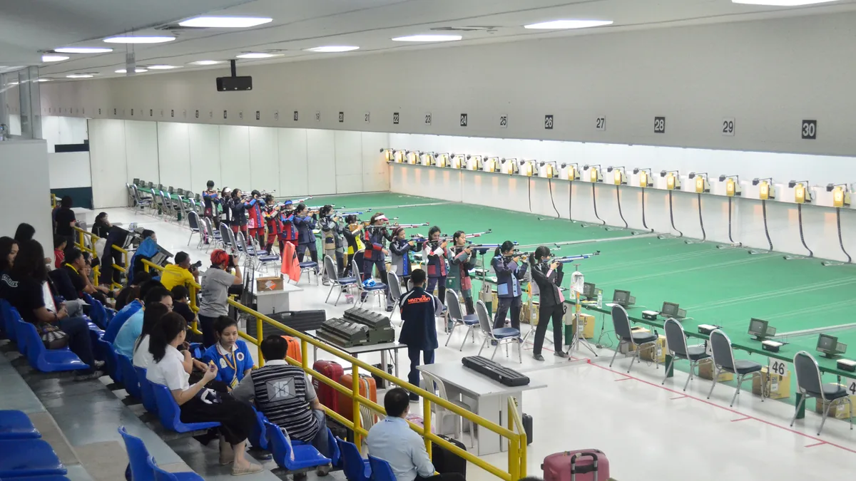 Atletas de tiro esportivo com proteção auricular e ocular em estande organizado